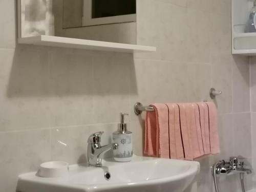 a white bathroom with a sink and a towel at Apartment Špehar in Seliste Dreznicko