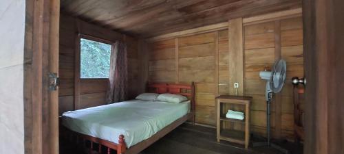 a bedroom with a bed in a wooden cabin at Cabaña Tu´ur in Lacanjá