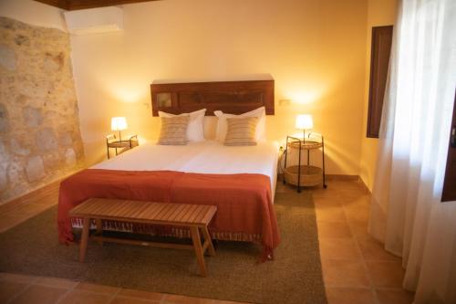a bedroom with a large bed and two lamps at O Pombal in Alcanena