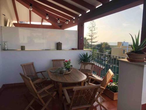 een terras met een tafel en stoelen op een balkon bij Sanlúcar Playa de las Piletas in Sanlúcar de Barrameda