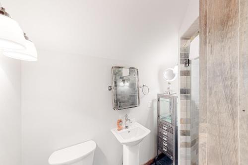 a white bathroom with a toilet and a sink at Chalet at the Base of Okemo Mountain in Ludlow