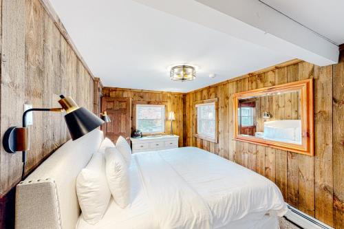 um quarto com uma cama branca e paredes de madeira em Chalet at the Base of Okemo Mountain em Ludlow