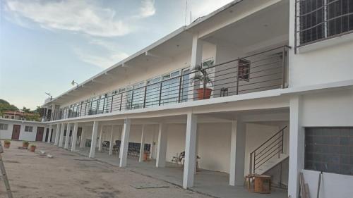a large white building with a balcony and stairs at Apartamentos Mundo Maya Habitaciones in Flores