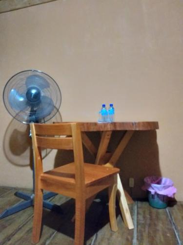 a desk with a chair and a fan and two bottles of water at Cabaña Tu´ur in Lacanjá