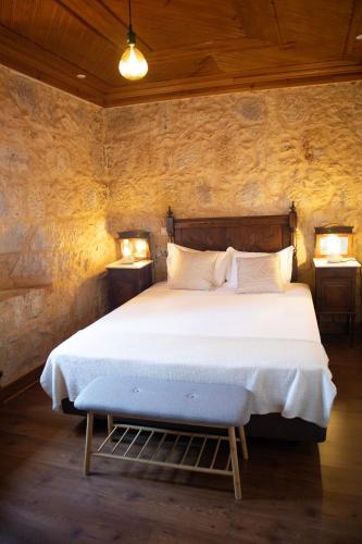 a bedroom with a large bed with two night stands at O Pombal in Alcanena