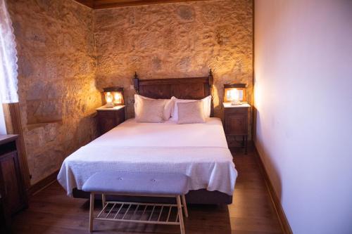 a bedroom with a bed and two lights on two tables at O Pombal in Alcanena