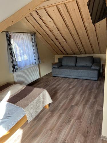 a bedroom with a bed and a couch in a attic at Janickowa Ostoja - Noclegi w Zakopanem in Zakopane