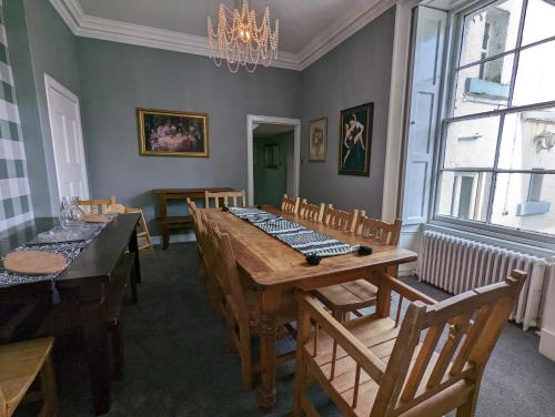 a dining room with a wooden table and chairs at Bonnyside House in Bonnybridge