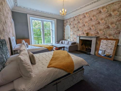 a large bedroom with two beds and a fireplace at Bonnyside House in Bonnybridge