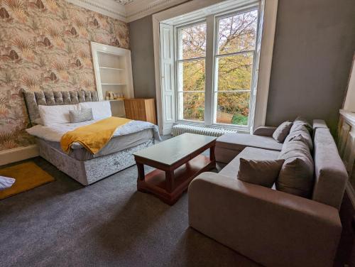 a living room with a couch and a bed at Bonnyside House in Bonnybridge