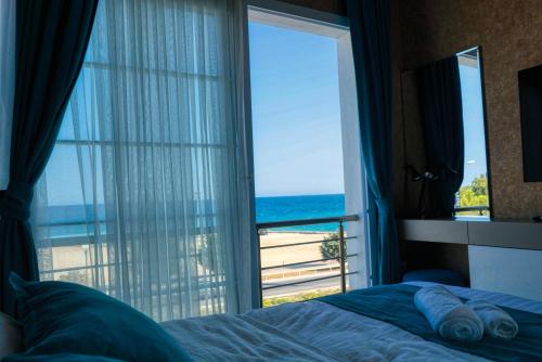 a bedroom with a window with a view of the beach at Osman Aga Hotel in Iskele