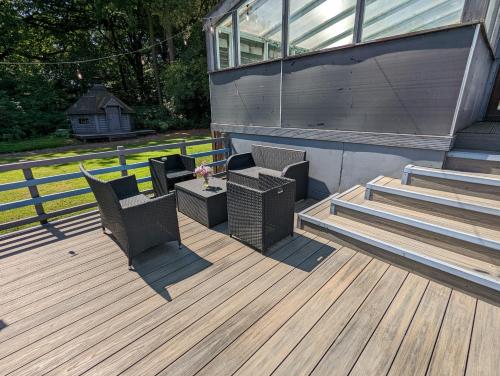 a deck with chairs and a table and stairs at Bonnyside House in Bonnybridge