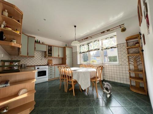 a kitchen with a table and chairs and a dog sitting on the floor at Willa Janina in Jelenia Góra