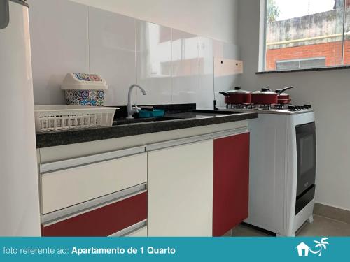 a kitchen with red and white cabinets and a sink at BEIRA MAR - PRAIA Do LÁZARO in Ubatuba