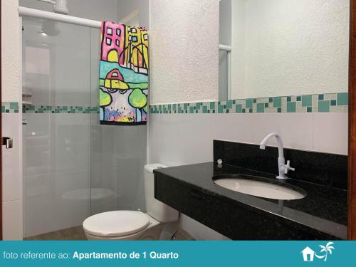 a bathroom with a toilet and a sink and a mirror at BEIRA MAR - PRAIA Do LÁZARO in Ubatuba