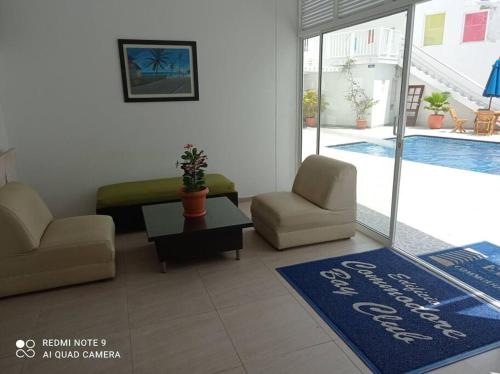 sala de estar con sofá, sillas y alfombra azul en Lindo apartamento en el mejor sector de la isla. piscina, bbq, playa a 30 metros, en San Andrés