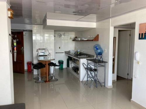 una cocina con encimera y taburetes. en Lindo apartamento en el mejor sector de la isla. piscina, bbq, playa a 30 metros, en San Andrés