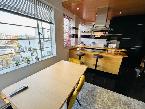 a kitchen with wooden tables and a large window at Beautiful Quality Apartment in Camden Town in London