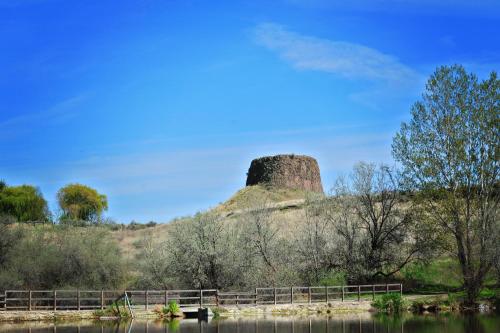 a rock sitting on top of a hill next to a river at Holiday Inn Express & Suites - Hermiston Downtown by IHG in Hermiston