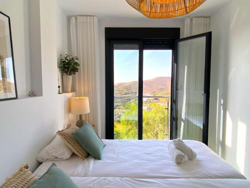 a bedroom with a bed and a large window at Balcon del Mar Seaview 114 Casasol in Nerja