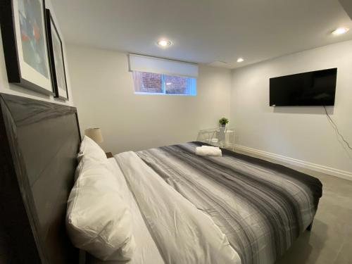 a bedroom with a bed and a flat screen tv at Yorkmills and Bayview !A Spacious and Modern Private Bdr with Shared Bathroom in Toronto