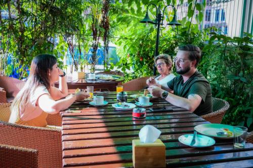 eine Gruppe von Menschen sitzt um einen Holztisch in der Unterkunft Kathmandu Prince Hotel in Kathmandu