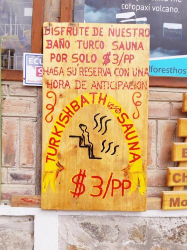 a sign on a wall with writing on it at Hostal Cloud Forest in Chugchilán