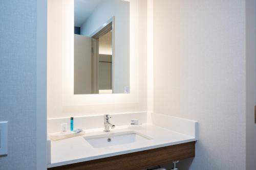 a bathroom with a white sink and a mirror at Holiday Inn Express Grover Beach-Pismo Beach Area by IHG in Grover Beach