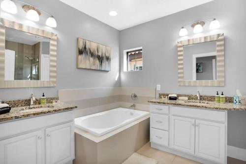 a white bathroom with two sinks and a tub at Large 4 bedroom with bunk room and 2 golf carts! in Destin