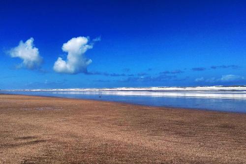 a sandy beach with waves in the ocean at Appartement sidi rahal in Berrechid