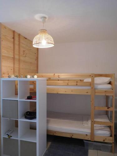 Cette chambre dispose de lits superposés et d'un lustre. dans l'établissement Superbe Studio au Crotoy accès direct plage, au Crotoy