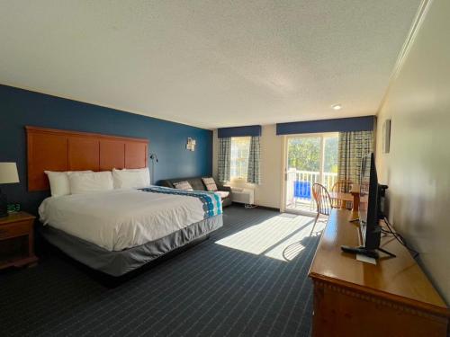 a hotel room with a bed and a television at The Lodge at Jackson Village in Jackson