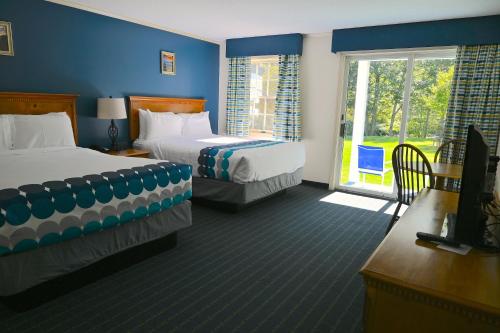 a hotel room with two beds and a window at The Lodge at Jackson Village in Jackson