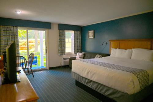 a hotel room with a bed and a living room at The Lodge at Jackson Village in Jackson