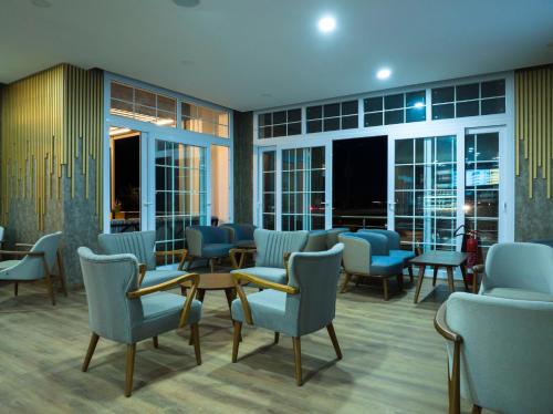 a waiting room with chairs and tables and windows at Osman Aga Hotel in Iskele