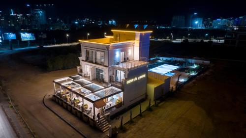 a tall building with a yellow roof at night at Osman Aga Hotel in Iskele