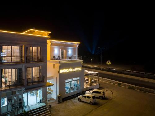 two cars parked in front of a building at night at Osman Aga Hotel in Iskele