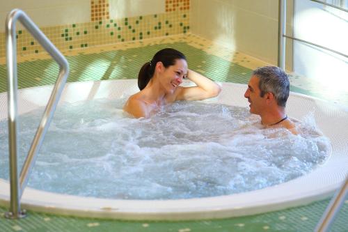 a man and a woman in a hot tub at Hotel Margareta in Balatonfüred