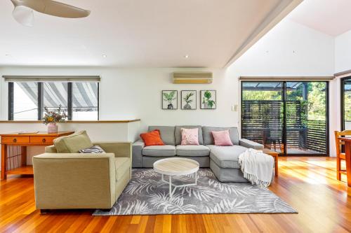 a living room with a couch and a table at Unwind at Secret Garden Maleny 3 BR Family Home in Maleny