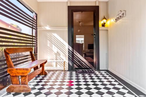 a porch with a bench and a checkered floor at Unwind at Secret Garden Maleny 3 BR Family Home in Maleny