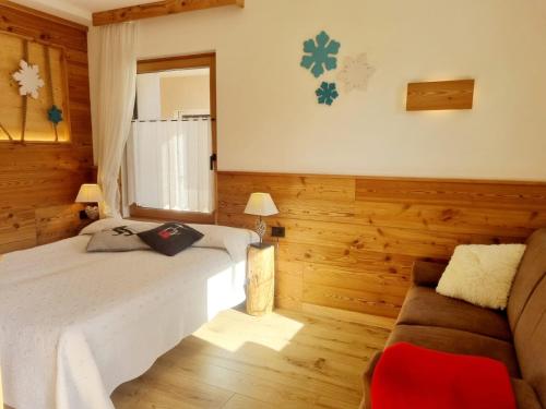 una camera da letto con un letto e un divano di Casa Dorigoni a Molveno a Molveno