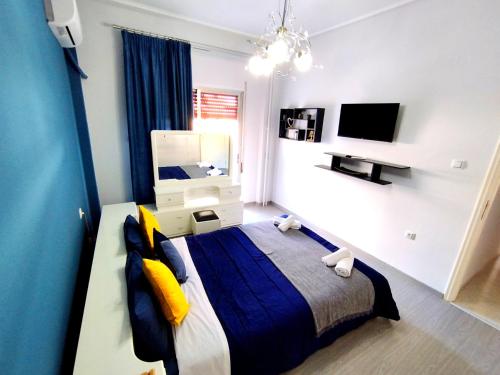 een slaapkamer met een groot bed en een televisie bij Sophie's Guest House in Volos