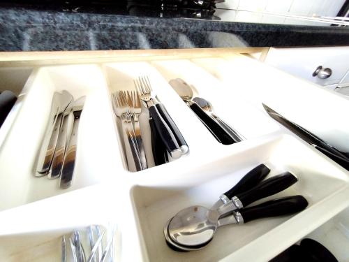 a white drawer with silver utensils in it at Sophie's Guest House in Volos