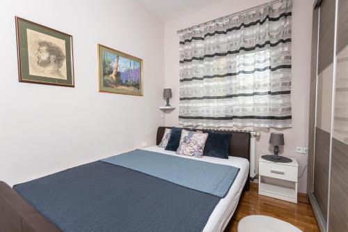 a bedroom with a bed and a large window at Apartman Gundulić in Vinkovci