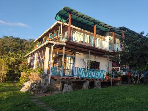 a large house with a balcony on top of it at Finca Jardín del Agua in Sasaima