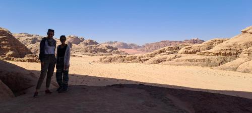 a man and a woman standing in the desert at Bronze Mountains Camp Wadi Rum in Aqaba