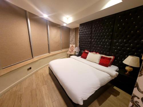 a bedroom with a large white bed with red pillows at Royal Residencia Centaurus in Islamabad