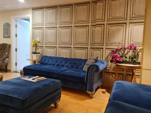 a living room with a blue couch and a table at Royal Residencia Centaurus in Islamabad