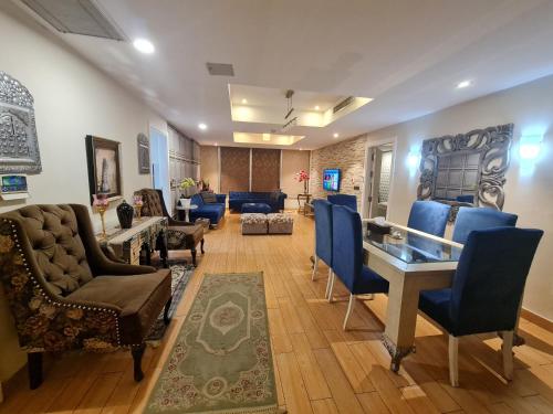 Royal Residencia Centaurus في اسلام اباد: غرفة معيشة مع كراسي زرقاء وطاولة