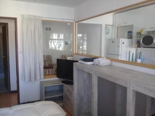 a room with a counter with a television and a kitchen at Centrico 05 in General Roca